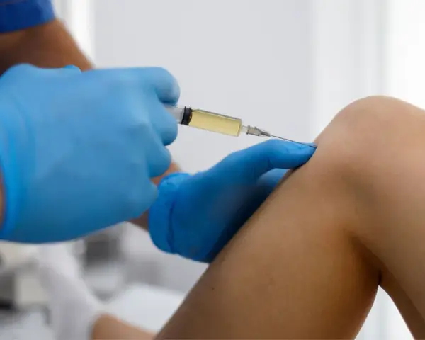 Arzt gibt Arthrose Spritze ins Knie.