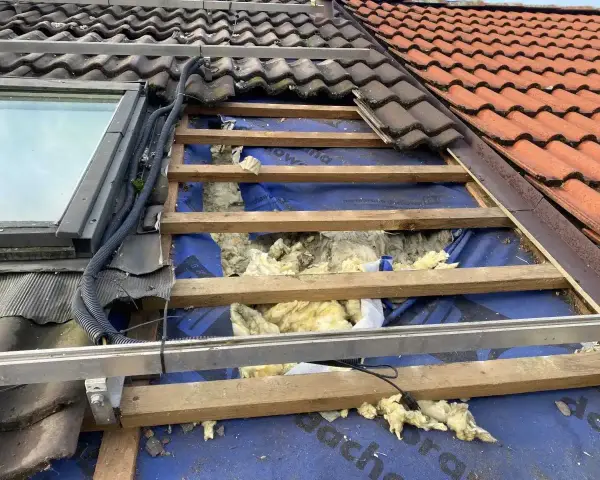 Uszkodzony dach z widoczną izolacją, jakby kuna zrobiła sobie tam gniazdo.