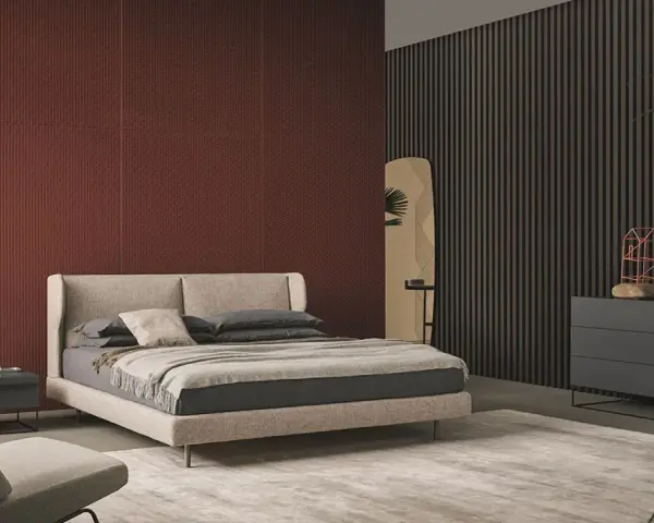 Habitación moderna con pared texturizada en rojo terracota, cama beige y cómoda gris. Inspírate para como pintar una habitacion.