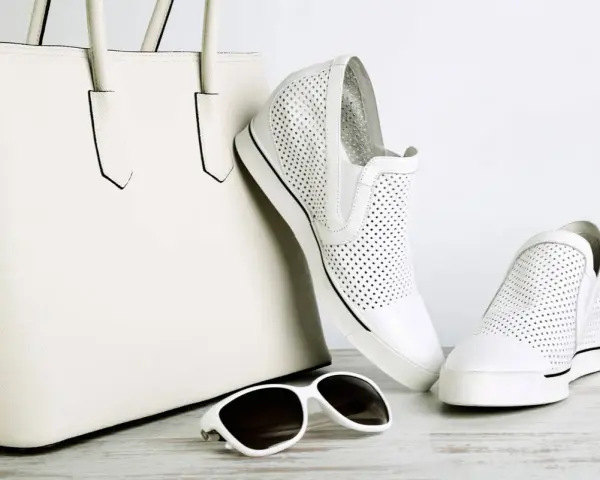 Borsa bianca e scarpe bianche traforate, un abbinamento perfetto. Gli occhiali da sole completano il look.
