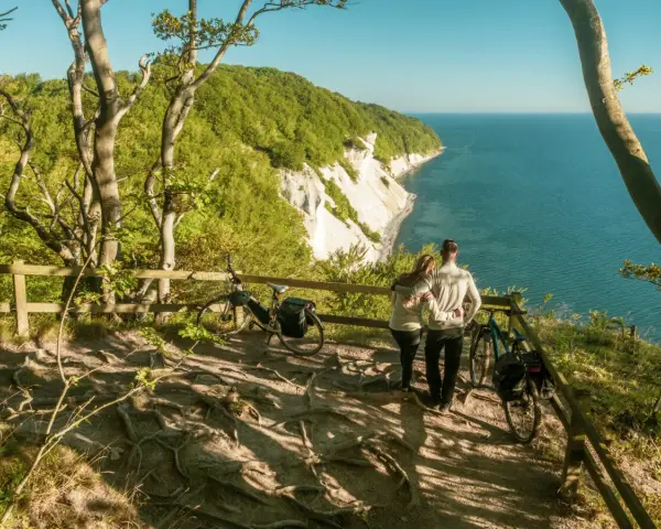 Para zakochanych podziwia widok na klify Møns Klint. Obok stoją rowery, gotowe do dalszej podróży.