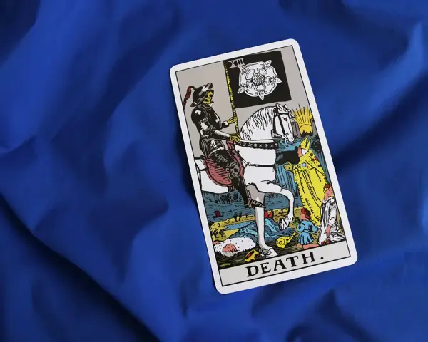 Tarot karta śmierci z rycerzem na białym koniu i flagą z różą. Symbolizuje koniec i nowy początek.
