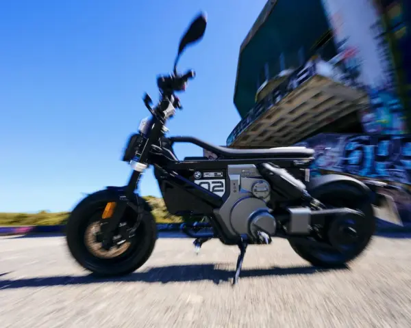 Czarny bmw skuter elektryczny w ruchu, z rozmytym tłem i graffiti.