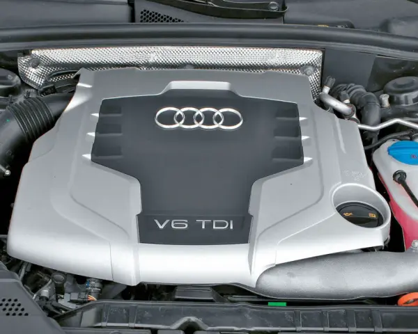 Silnik V6 TDI Audi z widocznym logo i oznaczeniem pojemności. Widać elementy układu dolotowego i płyny eksploatacyjne.