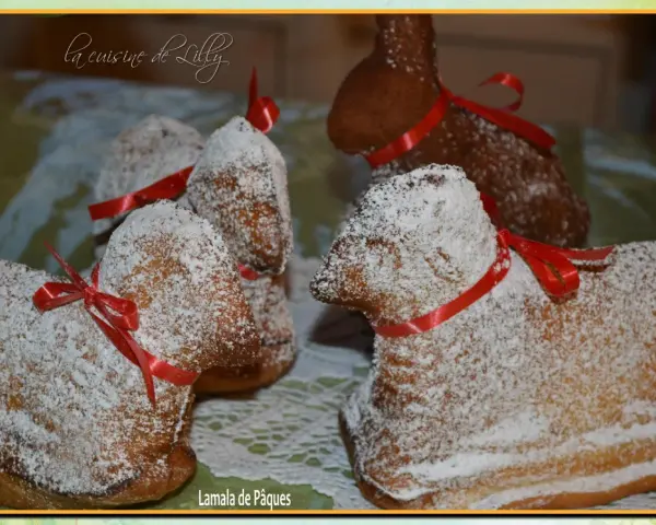 Lamala de Pâques, une recette de grand-mère pour un dessert festif. Ces agneaux en gâteau, saupoudrés de sucre glace et ornés de rubans rouges, évoquent la tradition.