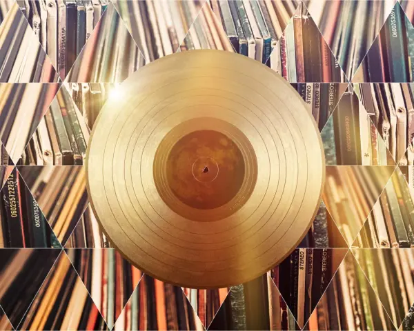 Złota płyta winylowa na tle stosów albumów. Czy to symbol tego, kto sprzedał najwięcej płyt w historii?