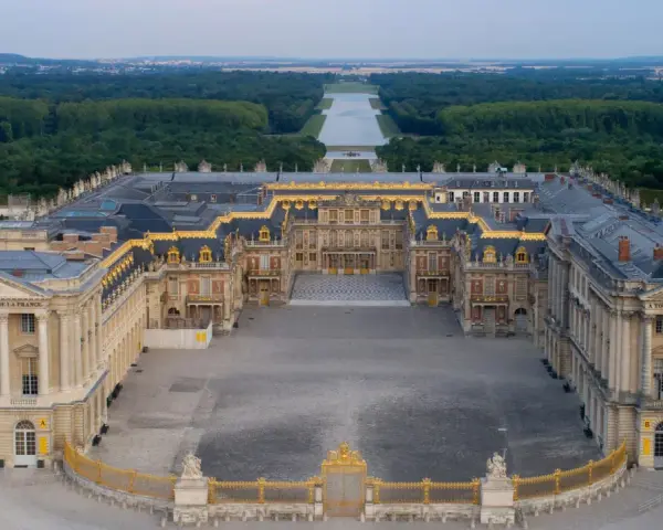 Le château de Versailles, construit par Louis XIV, s'étend majestueusement avec ses cours pavées et ses jardins.