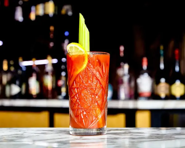 En perfekt Bloody Mary med selleri och citron, redo att avnjutas vid baren.