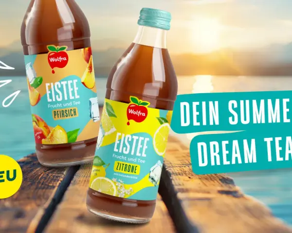Zwei Flaschen Wolgra Eistee, Pfirsich und Zitrone, stehen auf einer Holzplanke am See. Perfekt für deinen Summer Dream Tea!