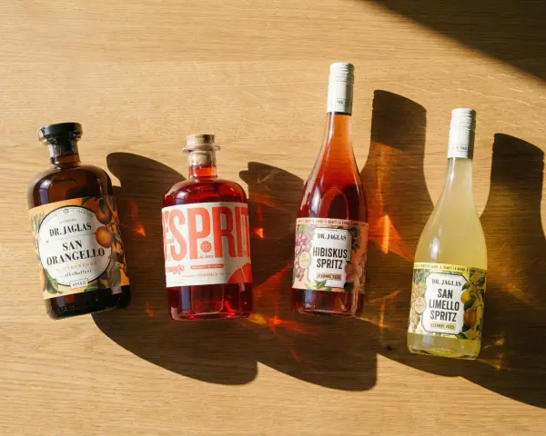 Vier Flaschen Dr. Jaglas Spritz: San Orangello, Sprit, Hibiskus Spritz und San Limello Spritz. Alle sind alkoholfrei, was bedeutet, dass sie keinen Neutralalkohol enthalten.