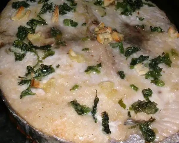 Rodaja de bonito al horno con ajo y perejil, ideal para recetas de bonito al horno.