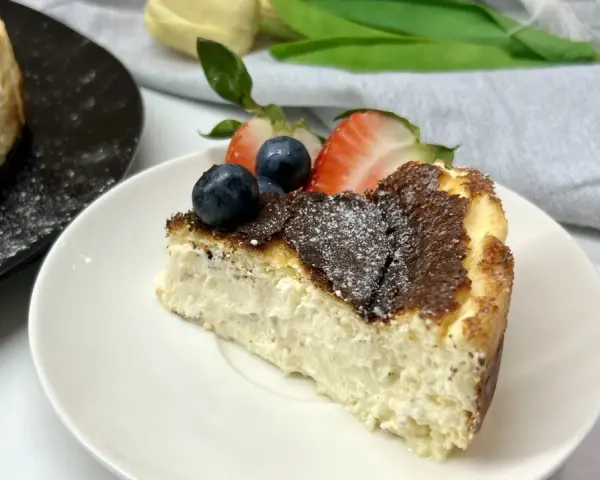 Pyszny sernik keto przepis na talerzyku, udekorowany borówkami i truskawkami. Idealny deser bez wyrzutów sumienia.