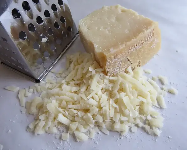Tarka i kawałek sera, z którego właśnie zrobiono garść tartego parmezanu. Idealny do posypania makaronu.