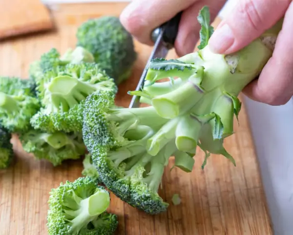 Färska broccolibuketter på en skärbräda, redo att tillagas för att bevara alla nyttiga vitaminer.