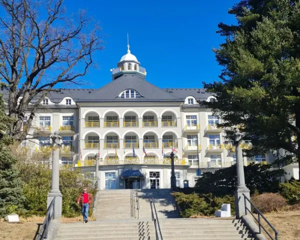 Piękny budynek sanatorium w Jeseniku, z charakterystycznymi arkadami i żółtymi balustradami. To jedna z głównych atrakcji regionu.