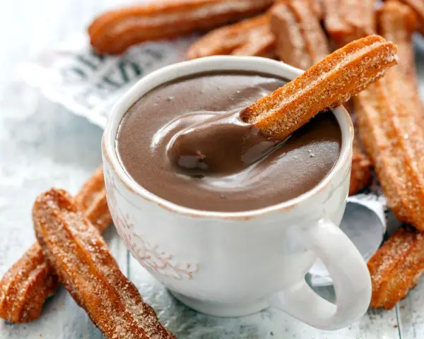 Ein Churro-Rezept zum Genießen: Knusprige Churros werden in heiße Schokolade getunkt.