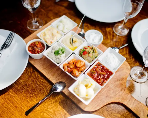 Meze-Platte mit verschiedenen Dips und Beilagen, wie Hummus und Salsa, serviert im Hasir Kreuzberg.