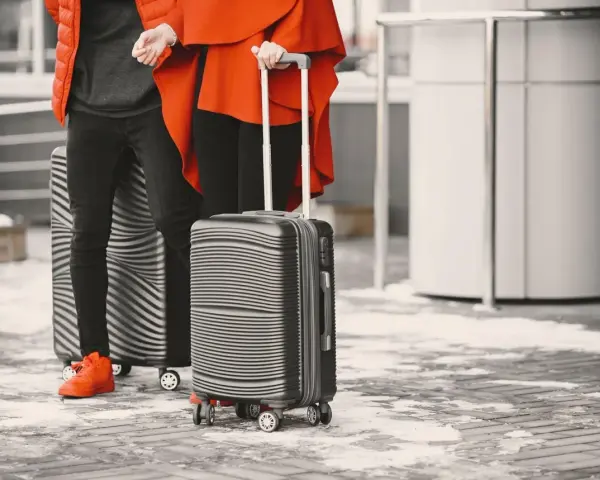 Para podróżnych z walizkami, idealnymi jako easyjet bagaż podręczny, gotowi na zimową podróż.