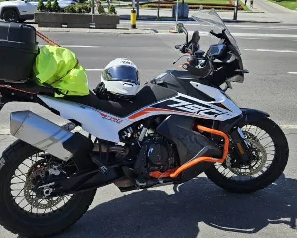 Motocykl KTM 790 Adventure gotowy na przygodę po NC500 Szkocja. Kask i jaskrawożółty pokrowiec na bagaż czekają na start.