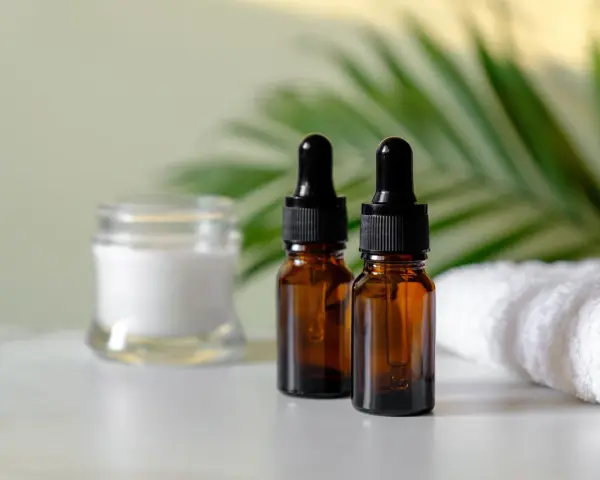 Dwa brązowe flakoniki z pipetką i słoiczek z kremem, obok biały ręcznik. Zastanawiasz się, czy serum można stosować codziennie?