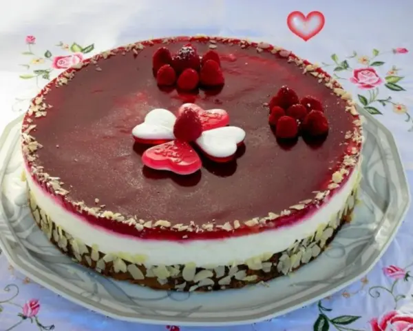 Himbeer Mohn Torte mit frischen Beeren und Herz-Gelees. Ein süßer Genuss für besondere Anlässe.