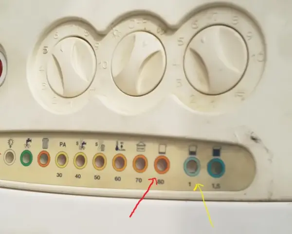 Pannello caldaia con manopole e spie. La spia rossa fissa indica un problema.