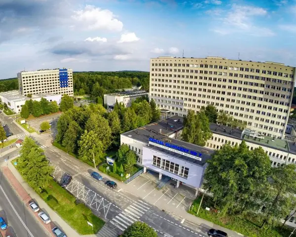 Widok z lotu ptaka na kompleks budynków szpitalnych otoczony zielenią.