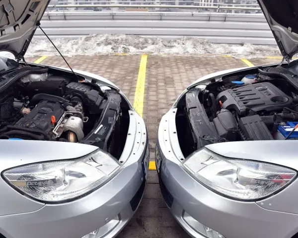 Dwa silniki samochodowe, jeden diesel, drugi benzyna, stoją obok siebie. Różnice w budowie są widoczne, choć oba napędzają auta.