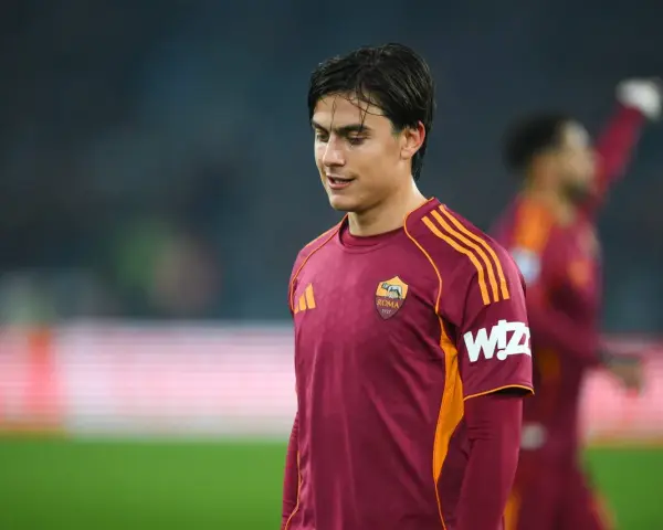 Piłkarz AS Roma w bordowej koszulce z pomarańczowymi pasami, gotowy do gry przeciwko Atalancie.