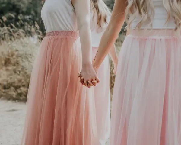 Dziewczyny w tiulowych, pudrowych sukienkach trzymają się za ręce. Ich styl to kwintesencja "soft girl".
