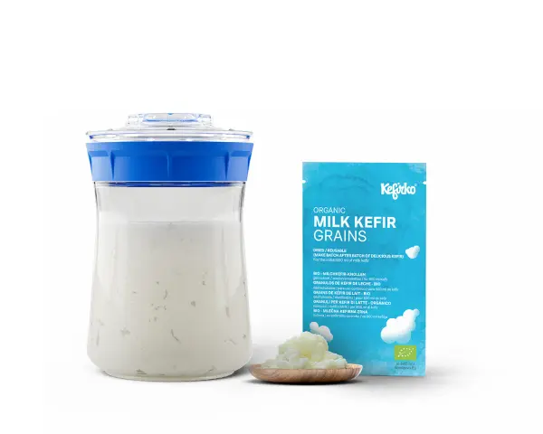 Kefirko Bio Milch Kefir Körner für gesunden Kefir. Ein Glas mit Kefir und eine Packung mit Kefir-Körnern.