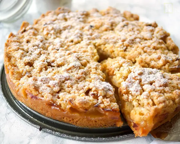 Ein goldbrauner Apfelkuchen mit Streuseln, bestäubt mit Puderzucker. Dieses Apfelkuchen Rezept sieht köstlich aus!