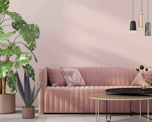 Divano rosa antico e tortora, piante verdi e lampade moderne creano un'atmosfera accogliente.