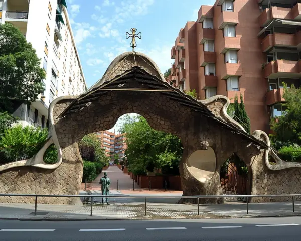 Portail organique, œuvre de Gaudí à Barcelone, avec une statue d'homme devant.