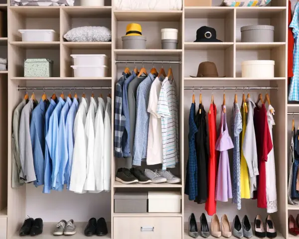 Szafa z ubraniami w stylu basic: koszule, sukienki, buty i akcesoria.