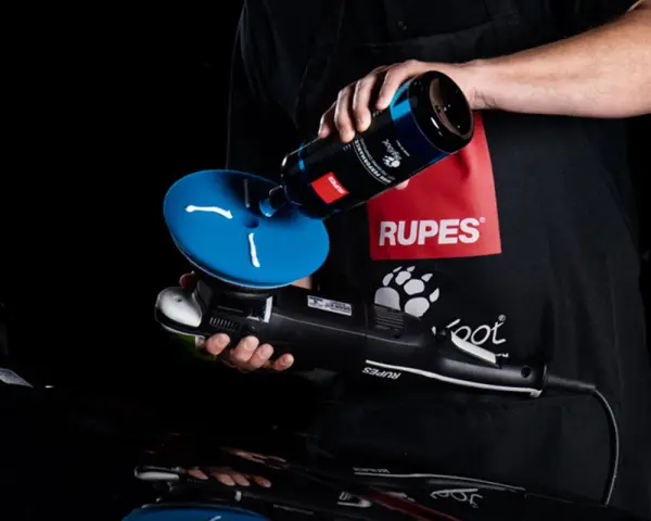 Person applicerar Rupes da coarse polermedel på en polertrissa.