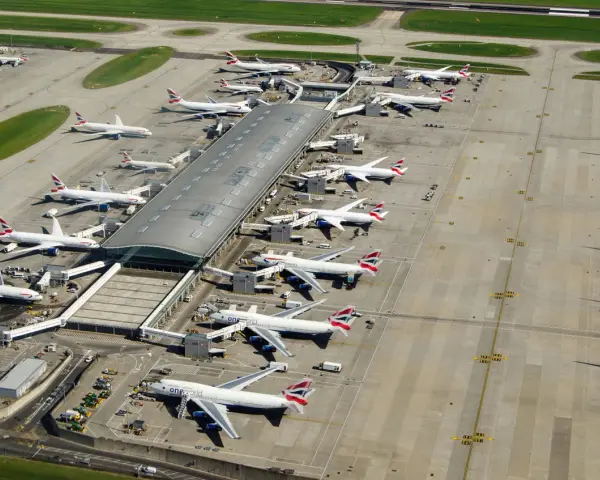 Lotnisko Heathrow tętni życiem, z wieloma samolotami British Airways czekającymi na pasażerów.