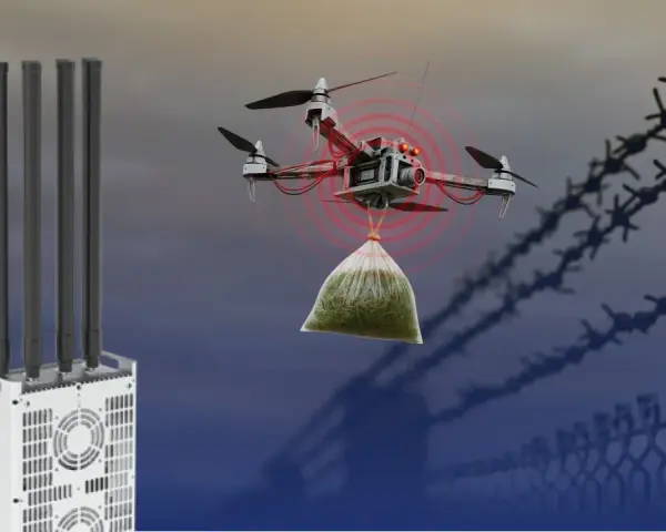 A drone carrying a bag of contraband is detected near a fence. A UAV jammer with multiple antennas stands ready to disrupt its flight.