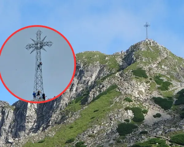Ludzie wspinają się na krzyż na Giewoncie. Czy krzyż na Giewoncie świeci? Widać go z daleka na tle błękitnego nieba.