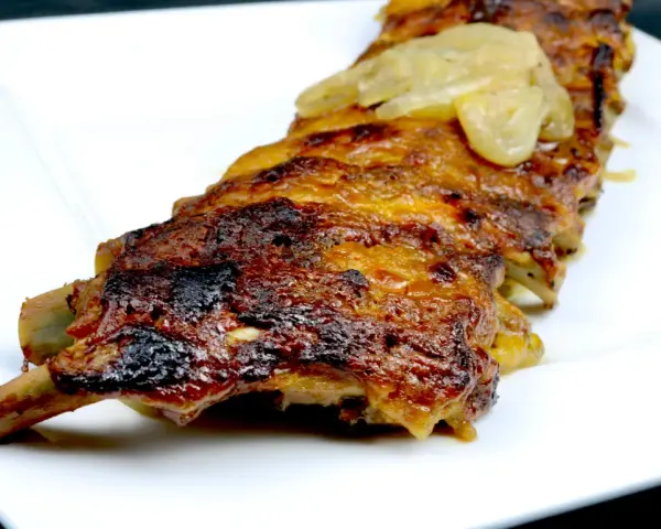 Saftige Rippchen, glasiert mit einer Honig-Senf-Marinade, serviert auf einem weißen Teller.