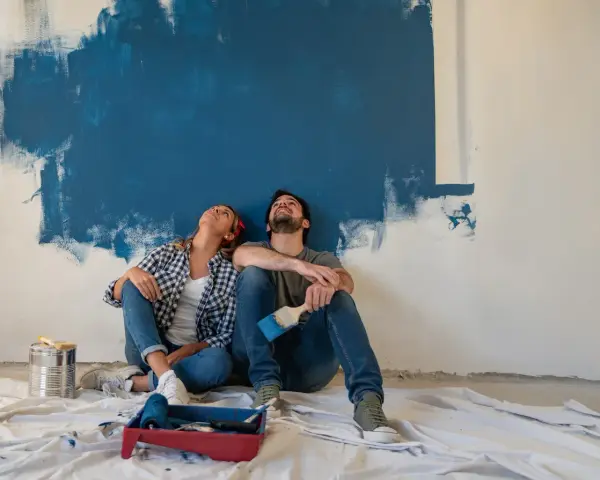 Coppia seduta sul pavimento, guarda in alto verso un muro dipinto di blu. Stacco tra parete e soffitto si o no?