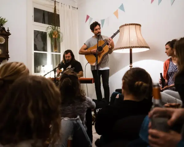 Gemütliches souly konzert berlin. Zwei Musiker spielen Gitarre und Keyboard, während das Publikum zuhört.