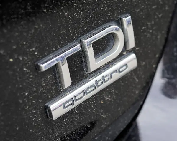 Emblemat TDI Quattro na zakurzonym czarnym lakierze. Zastanawiasz się, audi q5 2.0 tdi ile oleju?