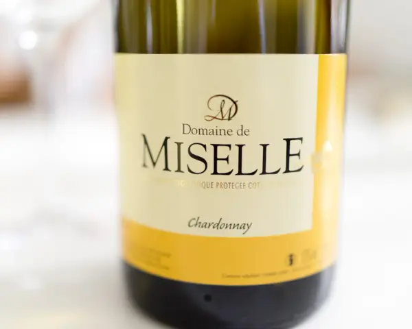 Butelka wina Domaine de Miselle, z wyraźnym napisem "Chardonnay". Idealne na letnie wieczory.
