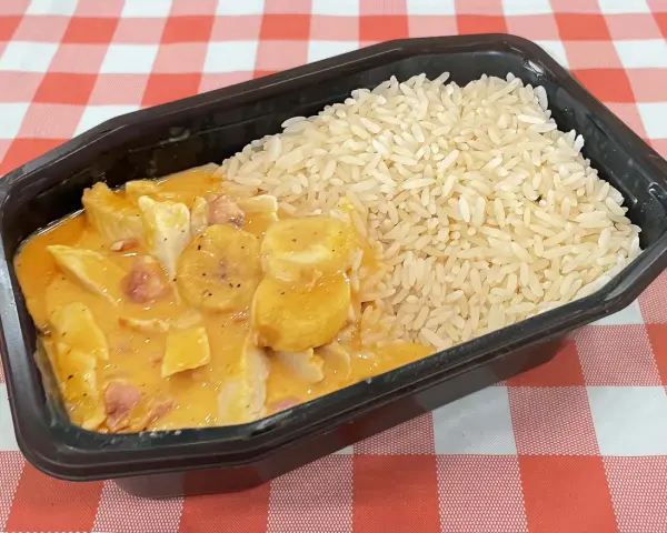 En portion flygande jacob med ris i en svart plastbehållare, serverad på en rödvitrutig duk.