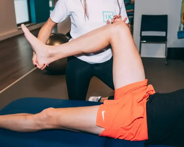 Kinésithérapeute examinant le genou d'un coureur souffrant de douleur.