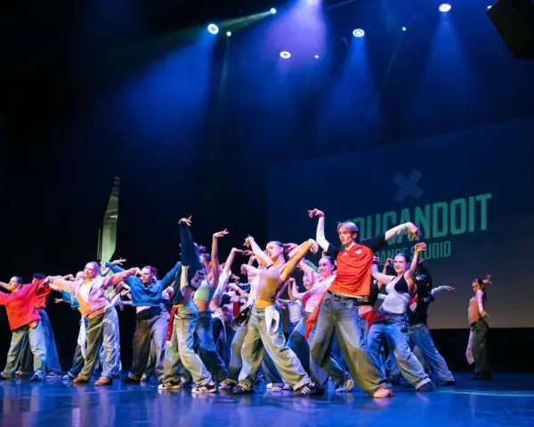 Tancerze na scenie, w ruchu, jakby tworzyli choreografię na żywo. To właśnie improwizacja co to – spontaniczność i kreatywność w tańcu.