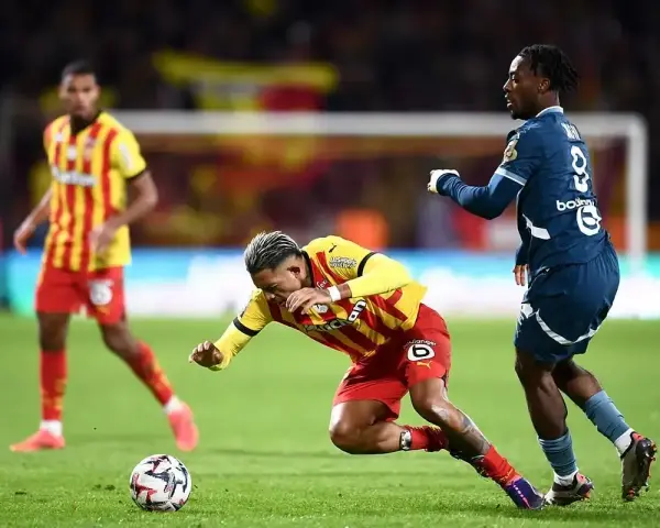 Piłkarz RC Lens w żółto-czerwonym stroju walczy o piłkę z zawodnikiem Stade Rennais.