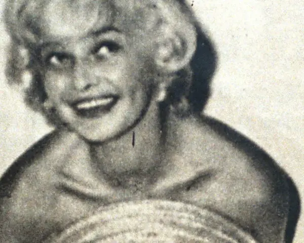 Uśmiechnięta Marilyn Monroe, ikona kina, w czarno-białym ujęciu. Jej imię zna cały świat.