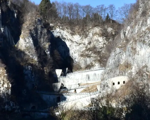 Strada a tornanti sul Passo San Boldo, con gallerie e muri di sostegno che si aggrappano alla roccia.